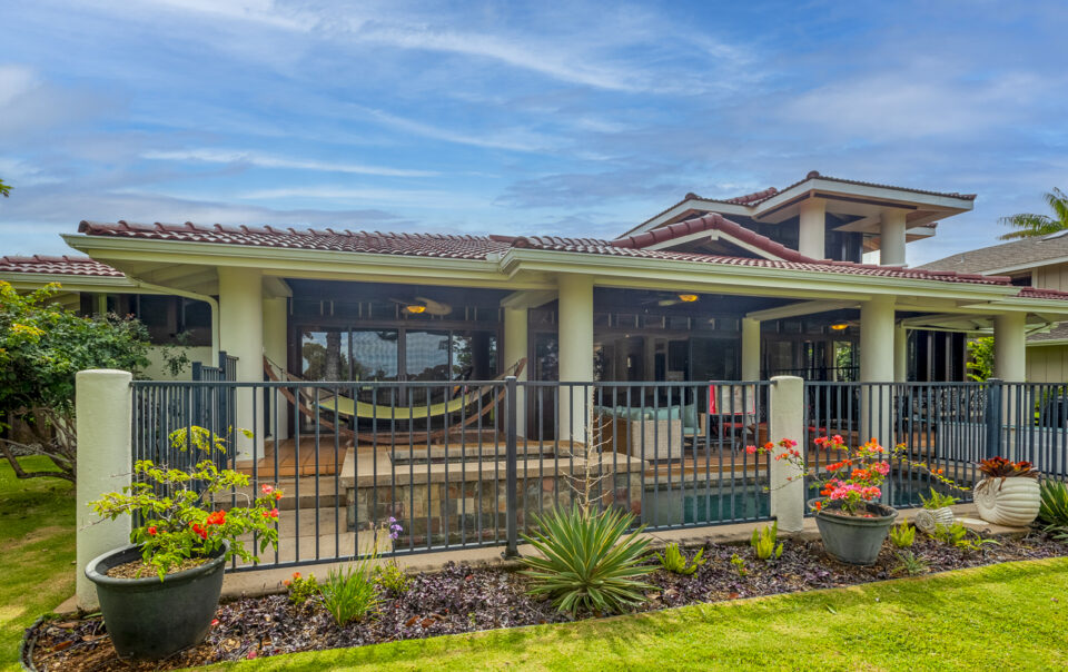 A large house with a hammock in the yard.