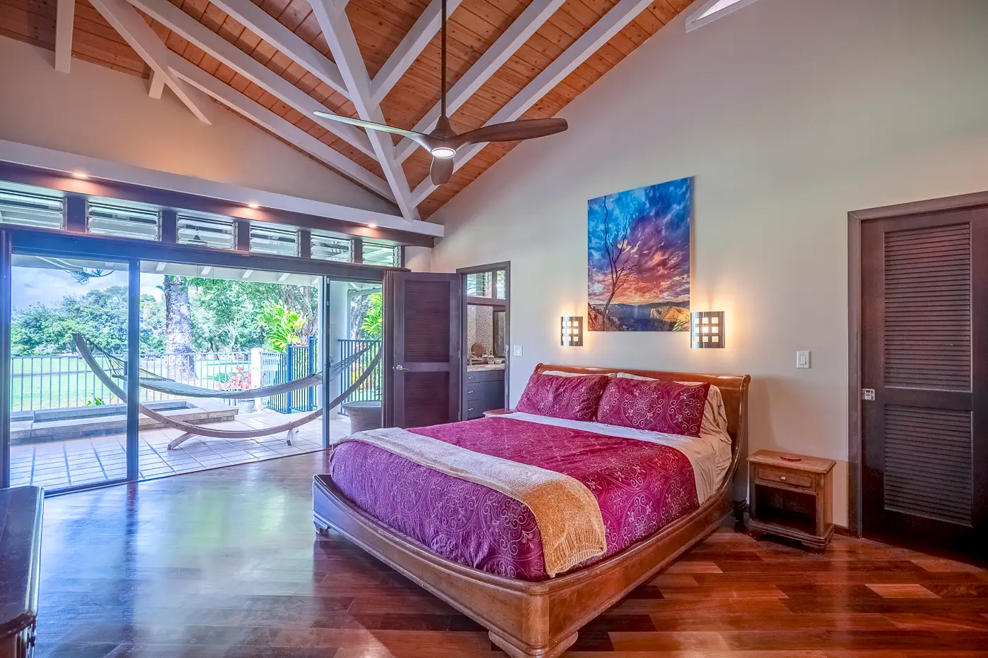 A bedroom with a large bed and wooden floors