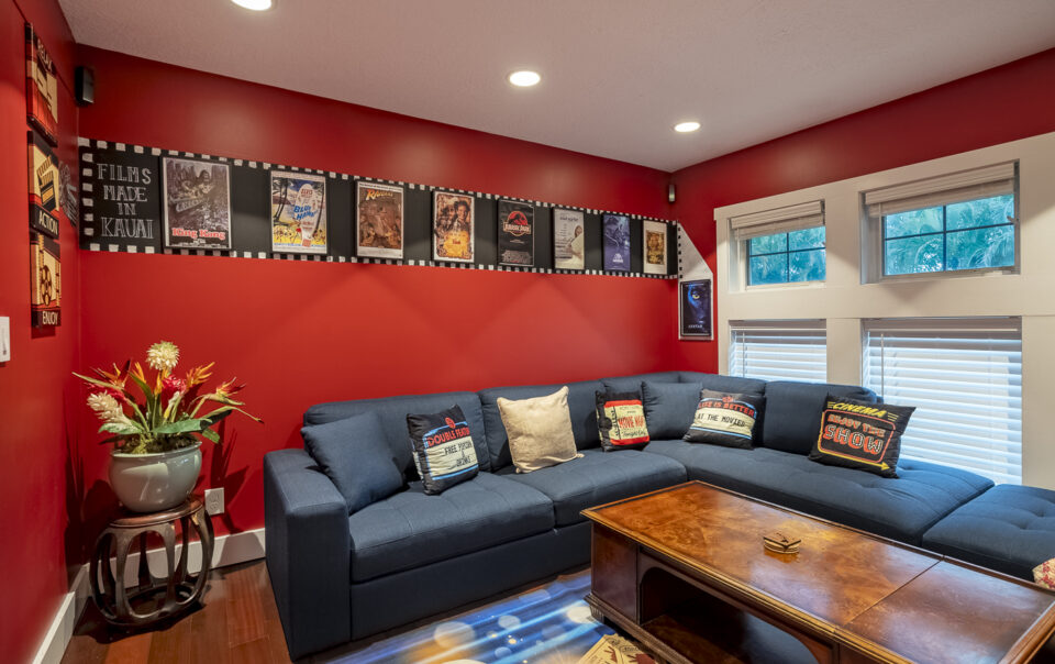 Home theater with red walls and movie posters.