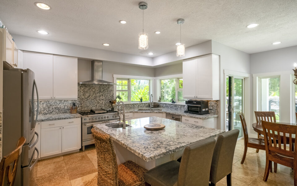 Modern kitchen with granite countertops and windows.
