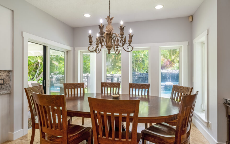 Dining area with large table and chandelier.