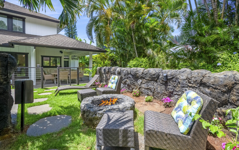 Lush garden with seating and fire pit.