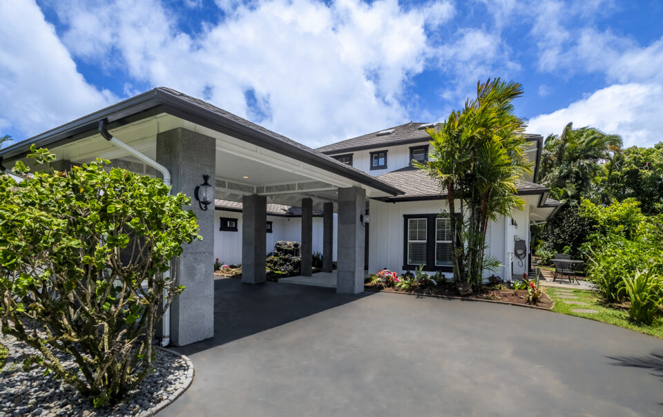 Modern home entrance with tropical landscaping.