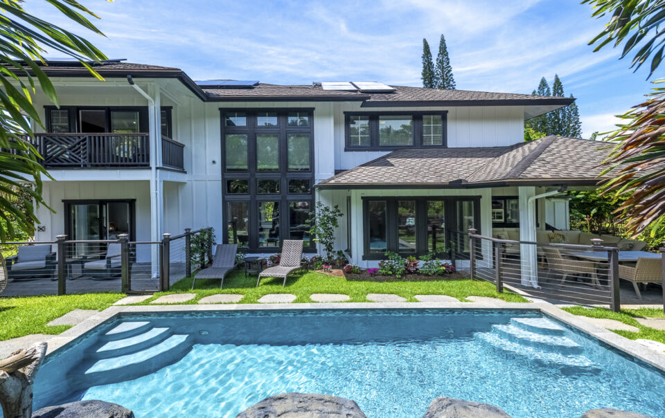 Modern home with pool and lush landscaping.