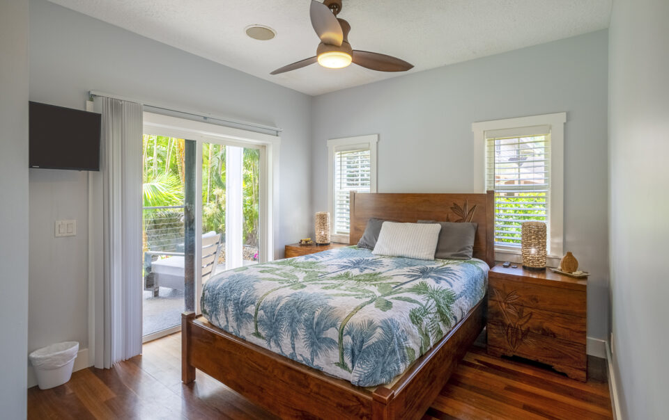 Tropical-themed bedroom with patio access.