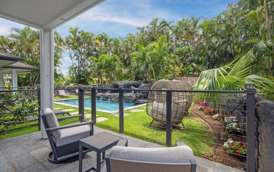 Lush backyard with pool and seating area.