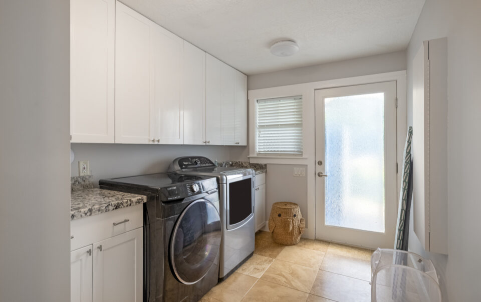 Laundry room with modern appliances and storage.