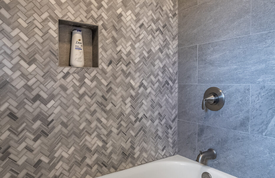 Modern bathroom with herringbone tile design.