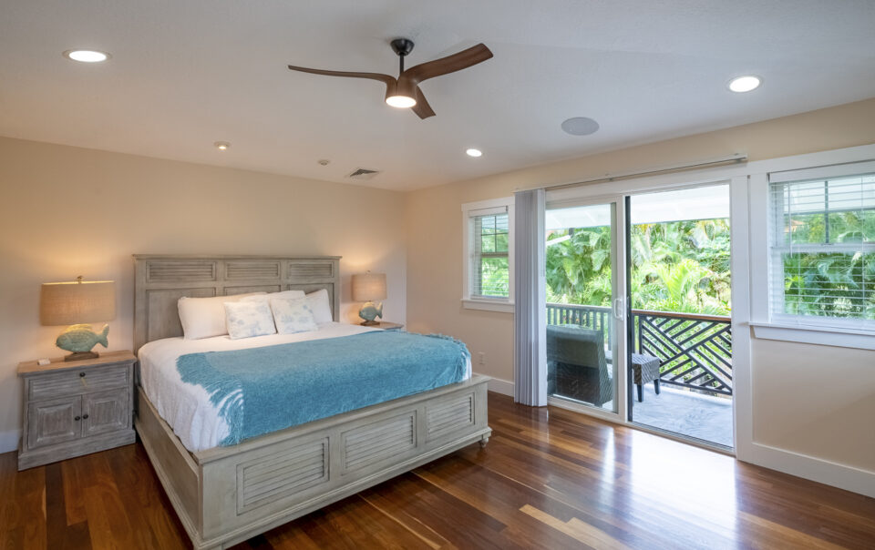 Bright bedroom with tropical accents and balcony.